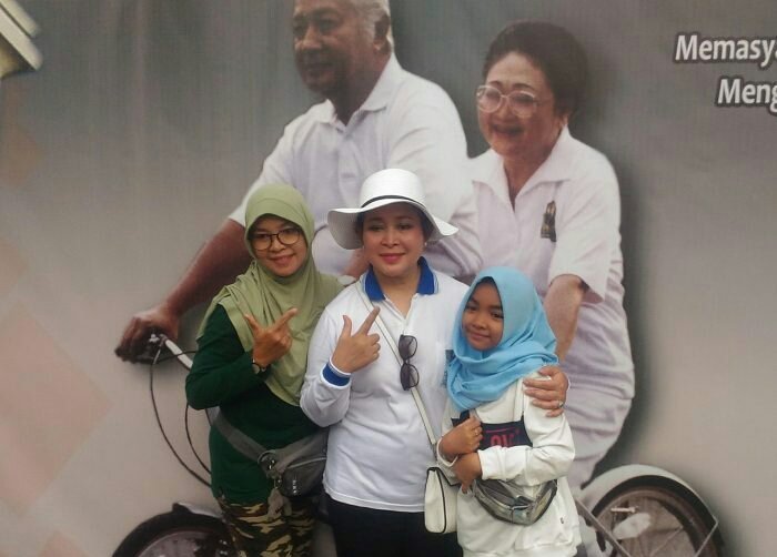 Poster Presiden Soeharto dan Ibu Tien bersepeda, dan orang-orang berebut berfoto di depannya bersama Siti Hediati Hariyadi, putri kedua almarhum Pak Harto yang akrab dipanggil Titiek Soeharto. Titiek Soeharto