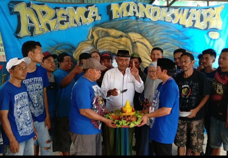 Pemotongan tumpeng pada perayaan HUT ke-32 Club Arema oleh sesepuh paguyuban Arema Manokwari Arema Manokwari