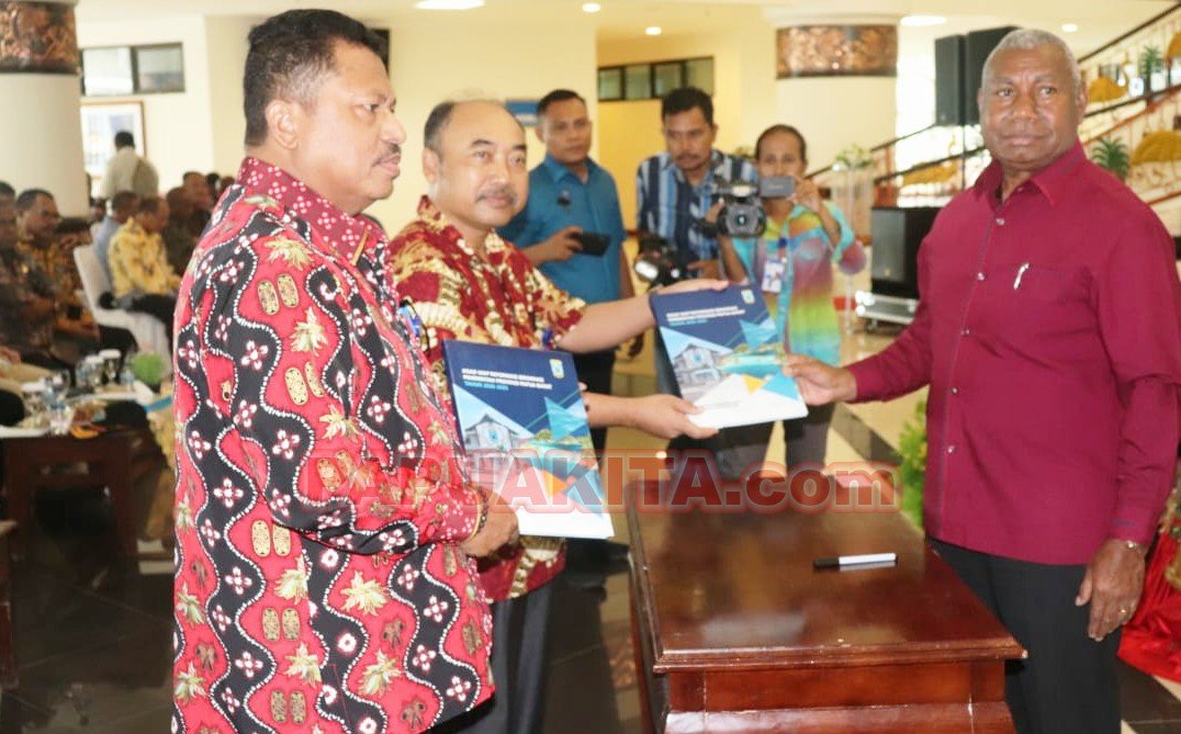 Gubernur Dominggus Mandacan ketika menyerahkan salah satu buku kepada Inspektur Papua Barat, Sugiyono pada acara pengucapan syukur tahun kerja 2020