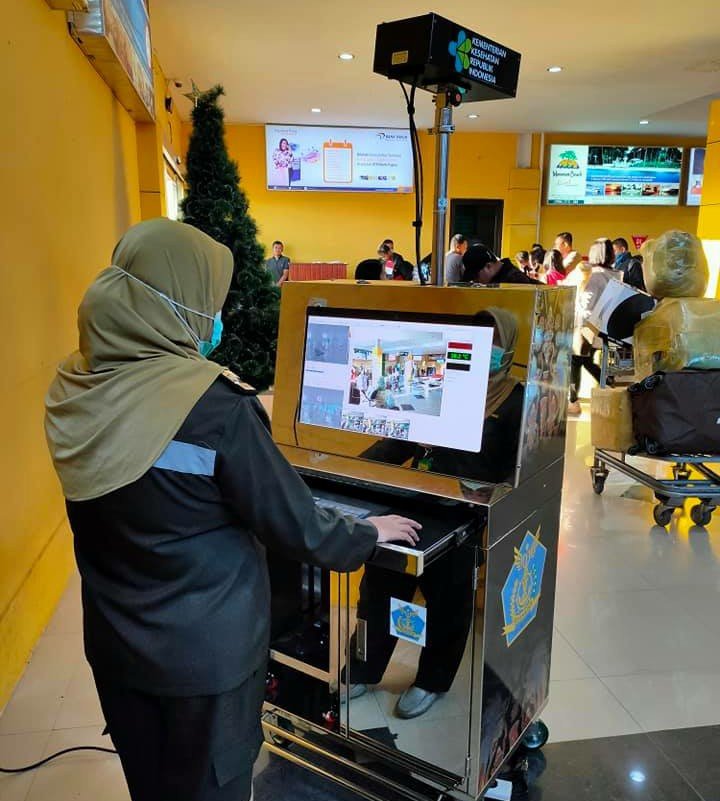Petugas KKP saat melakukan pemantauan dengan menggunakan thermal scanner terhadap para penungpang yang tiba maupun berangkat melalui Bandara Rendani