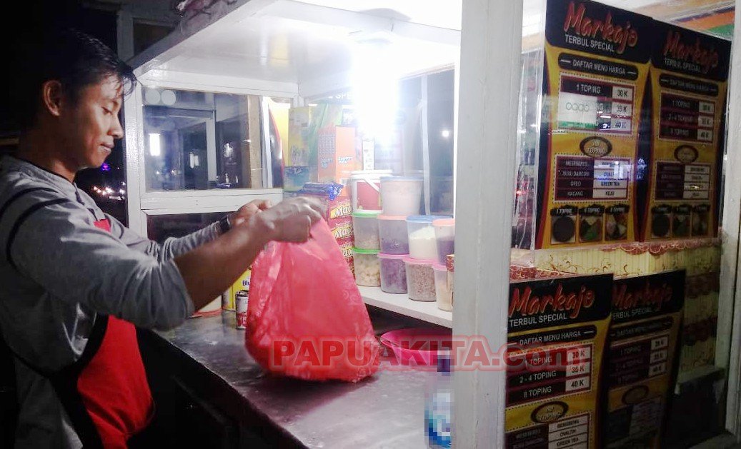 Andre pemilik usaha Terang Bulan Markajo di sela melayani pelanggan.