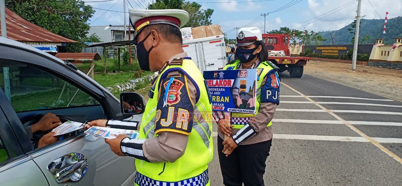 Anggota Ditlantas Polda PB saat membagikan brosur tentang tertib berlalu lintas dan protokol kesehatan adaptasi kebiasaan baru