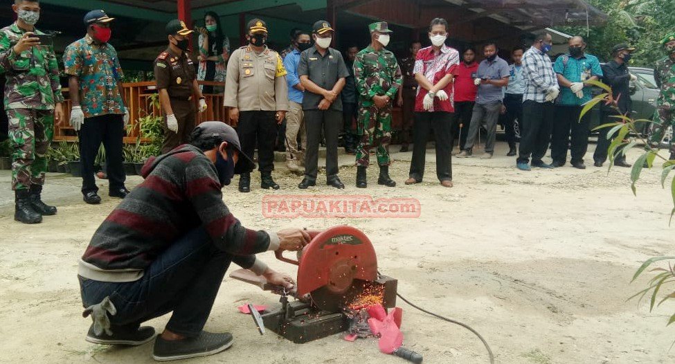 Petugas saat memotong sebuah senpi rakitan menggunakan mesin gurinda pada acara pemusnahan barang bukti yang dipakai untuk melakukan kejahatan