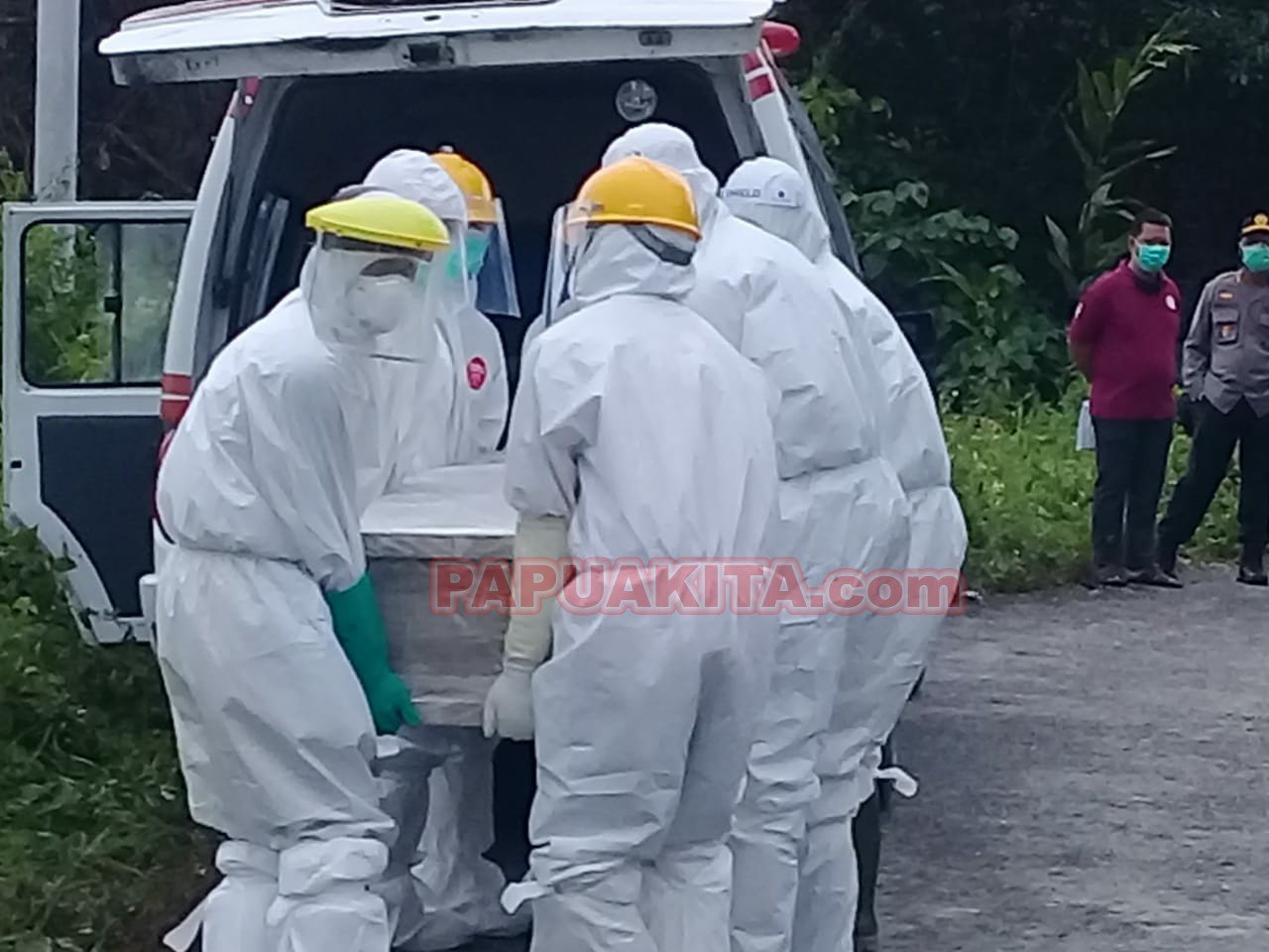 Petugas medis saat mengangkat jenazah TP, pasien positif Covid-19 yang meninggal untuk dimakamkan di pemakaman khusus di Kampung Warayaru
