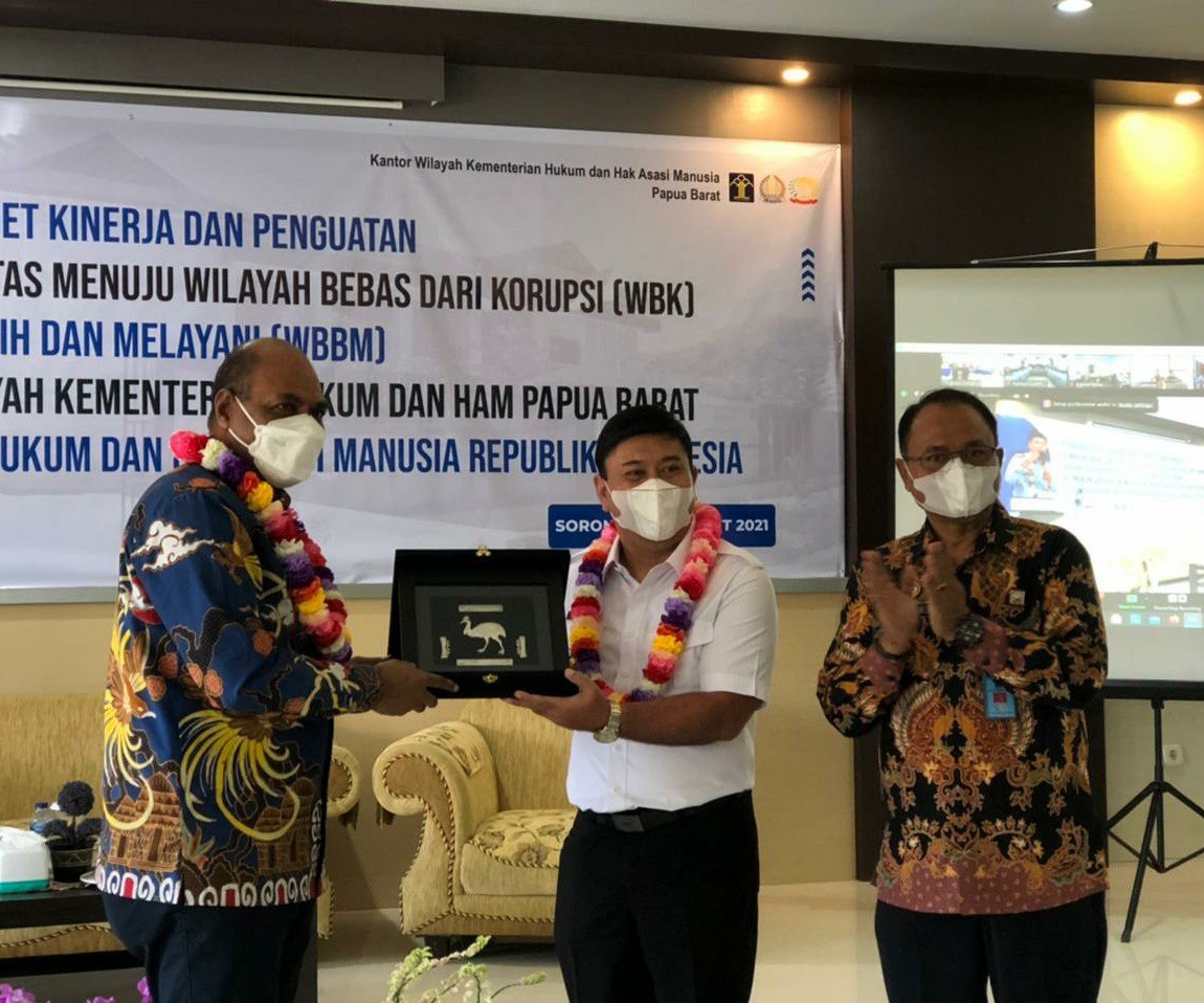 Wakil Gubernur Papua Barat Mohamad Lakotani memberikan plakat bergambar Burung Kasuari, logo Provinsi Papua Barat kepada Staf Khusus Menteri Hukum dan HAM, Fajar B.S Lase