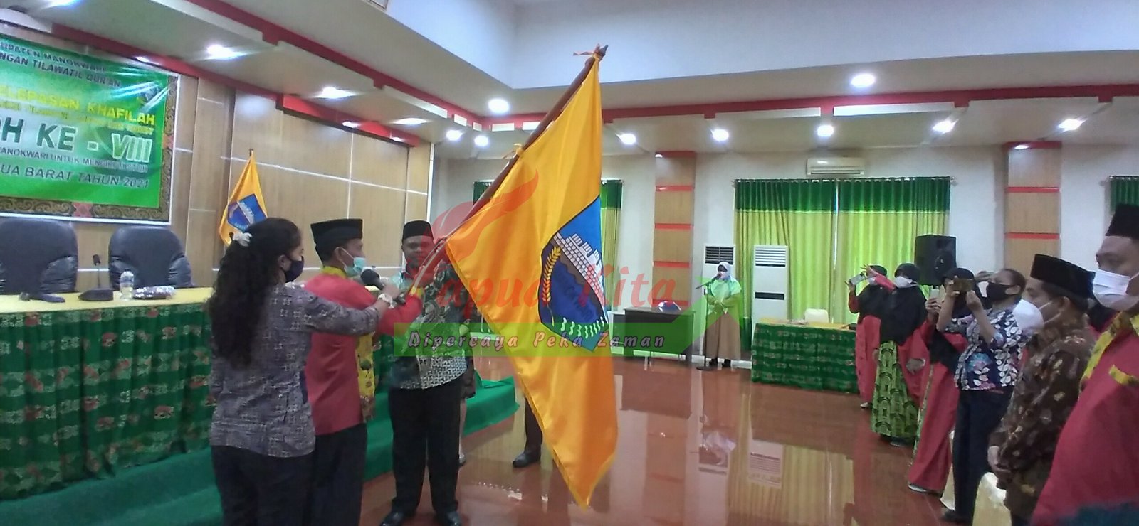 Bupati Hermus Indou menyerahkan pataka kepada ketua LPTQ, Aljabar Makatita pada acara pelepasan kafilah STQH Kabupaten Manokwari