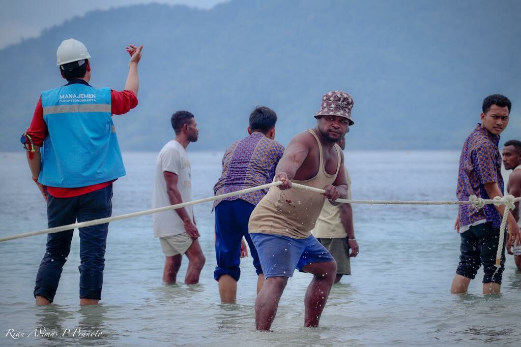 Warga bersama dengan Petugas PLN mengevakuasi material untuk pendirian PLTS di Kabupaten Raja Ampat