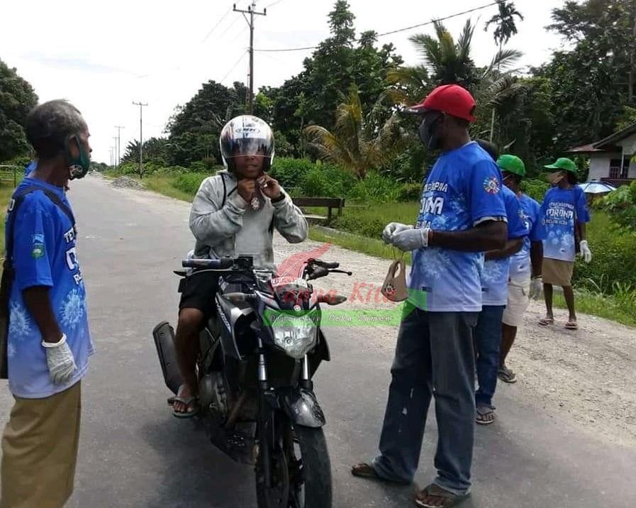 Relawan PPKM Mikro Kampung Uriemi, Distrik Rasiei, Kabupaten Teluk Wondama saat membagikan masker kepada warga