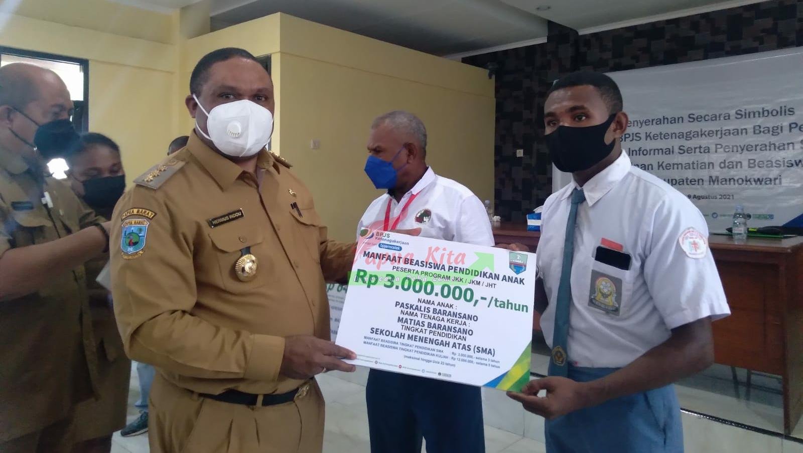 Bupati Hermus Indou menyerahkan santunan program kepesertaan jaminan sosial ketenagakerjaan berupa manfaat beasiswa kepada ahli waris dari salah seorang peserta