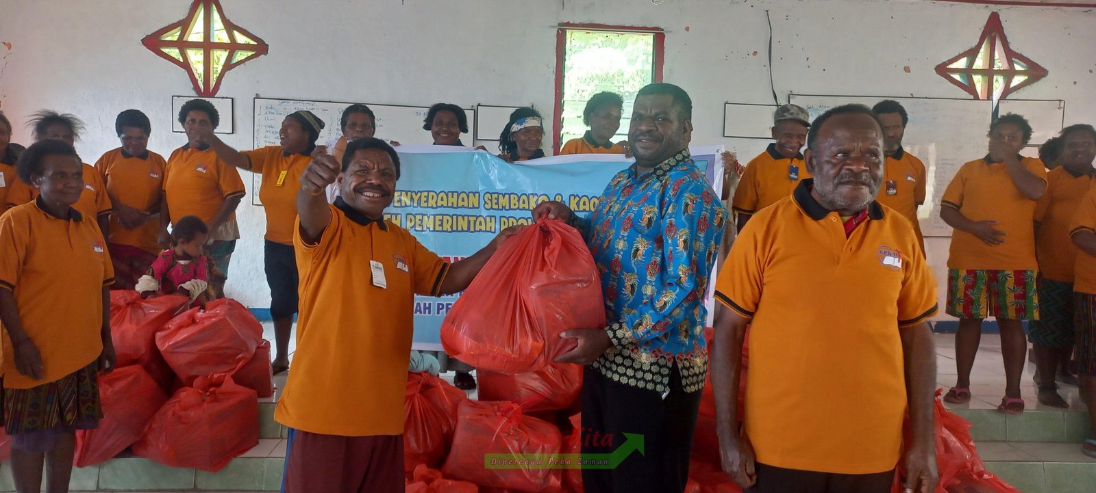 Ketua Panitia penyaluran bantuan kasih natal Aprinus Dowansiba ketika menyerahkan bantuan secara simbolis kepada salah satu warga di Kampung Mbenti, Minyambouw