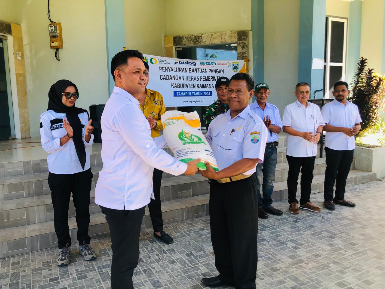 Asisten I Setda Kaimana, Yacob Ahimza Irre Warere saat serahkan secara simbolis bantuan pangan beras ke perwakilan Distrik Kaimana