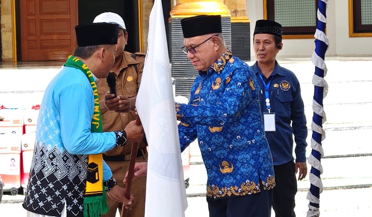 Bupati Kaimana, Hasan Achmad saat menyerahkan bendera rombongan jamaah calon haji asal Kaimana ke kepada Ketua rombongan di Halaman Masjid Baiturrahim Kampung Seran Bupati Kaimana, Hasan Achmad saat menyerahkan bendera rombongan jamaah calon haji asal Kaimana ke kepada Ketua rombongan di Halaman Masjid Baiturrahim Kampung Seran
